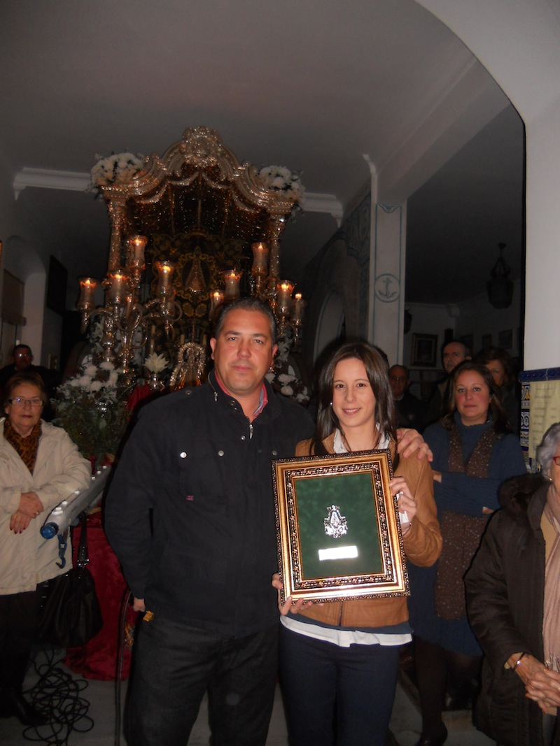 El Presidente de la Hermandad, Pedro Jesús Álvarez, entrega a Laura Reina un cuadro con la medalla de la Hermandad