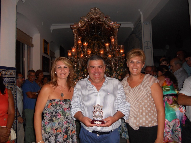 José Manuel Escobar, en nombre de la Peña La Manuela, recibe un recuerdo de manos de las Hermanas Mayores, Carmen Prieto y Sara Cáceres