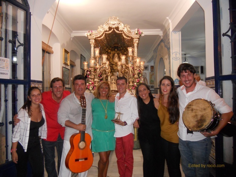 Nacho Vinagre, Joaquín Pandolfo y sus amigos acompañan a la Hermana Mayor, Juana Rodríguez, en esta foto de familia ante la Carreta del Simpecado