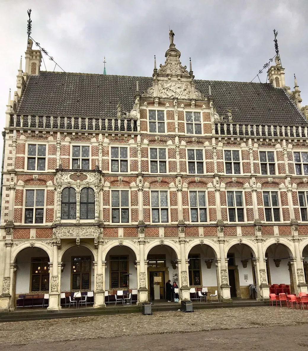 El histórico ayuntamiento de Bocholt, NRW, Alemania. El histórico ayuntamiento se encuentra en el centro de la ciudad de Bocholt, donde confluyen las calles comerciales del centro peatonal. La plaza del mercado rectangular está dominada por el ayuntamiento. Se encuentra frente a la plaza del mercado, de modo que el lado del alero actúa como fachada de exhibición, no el lado del frontón como en Münster, por ejemplo.