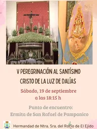 Altar con imagen del Cristo crucificado rodeado de flores blancas y estandarte bordado con la Virgen del Rocío y texto El Ejido Almería