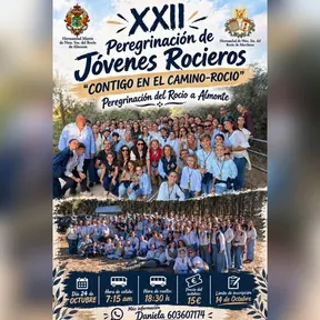 Grupo numeroso de jóvenes y adultos posando al aire libre en un entorno natural durante la peregrinación rociera con cielo despejado y árboles al fondo