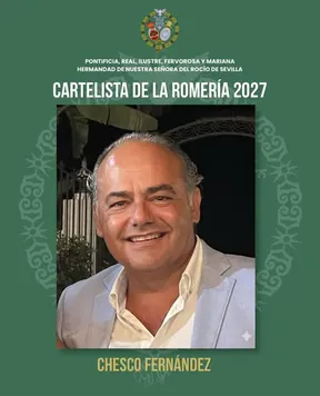 Hombre sonriente con chaqueta clara y camisa blanca posando en interior con fondo oscuro, en cartel oficial de la Hermandad del Rocío de Sevilla para 2027