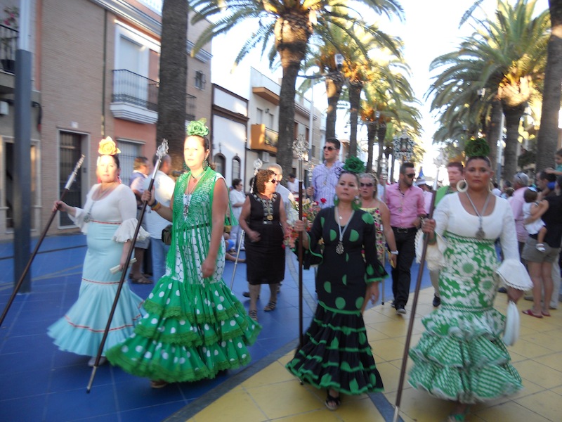 Por Las Palmeras haciendo la salida y ante la Virgen del Carmen una vez hecha la ofrenda de flores y alimentos.