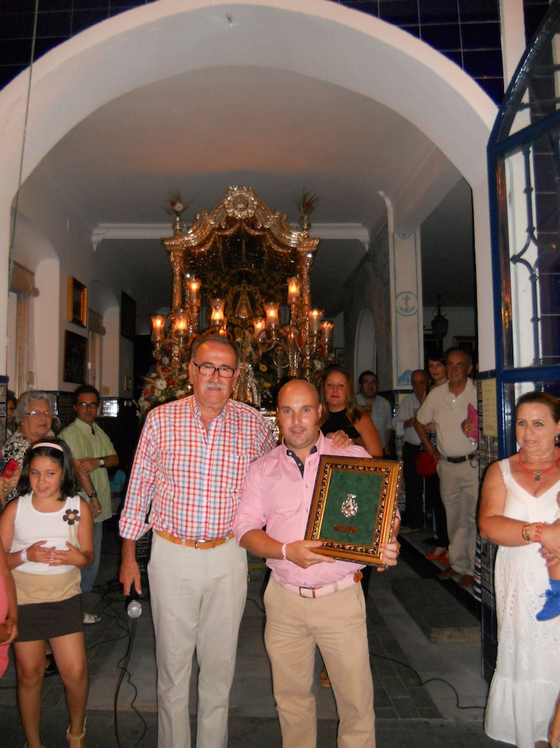 El Presidente de la Hermandad le hace entrega a David Garzón de un cuadro con la medalla