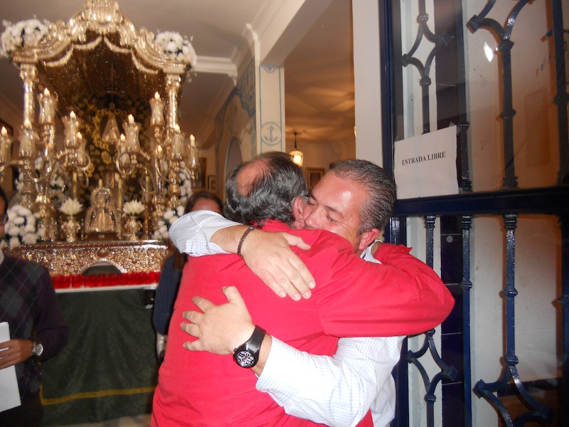 Emocionado abrazo ante el Simpecado que se dan el Presidente Francisco Amorós y el próximo Pedro Jesús Álvarez
