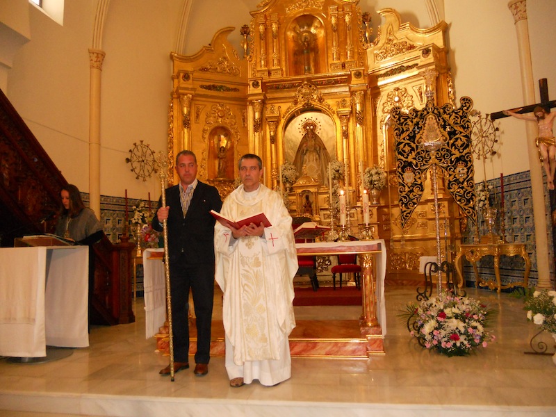 Mientras la Secretaria lee el Acta del Obispado, el sacerdote D. Juan Manuel Lagares sostiene en sus manos los Evangelios en presencia del Presidente de la Hermandad, Pedro Jesús Álvarez como testigo del acto