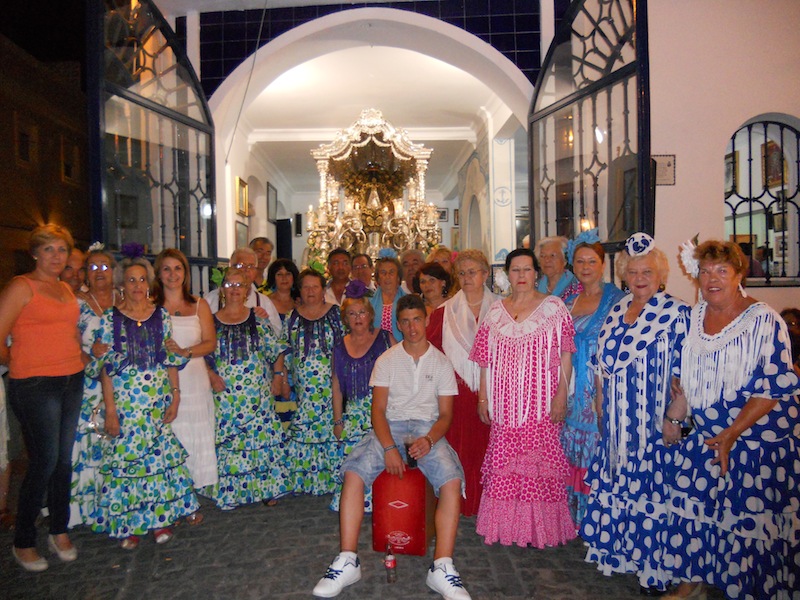 Foto de familia junto con las Hermanas Mayores ante la Carreta que porta nuestro Simpecado