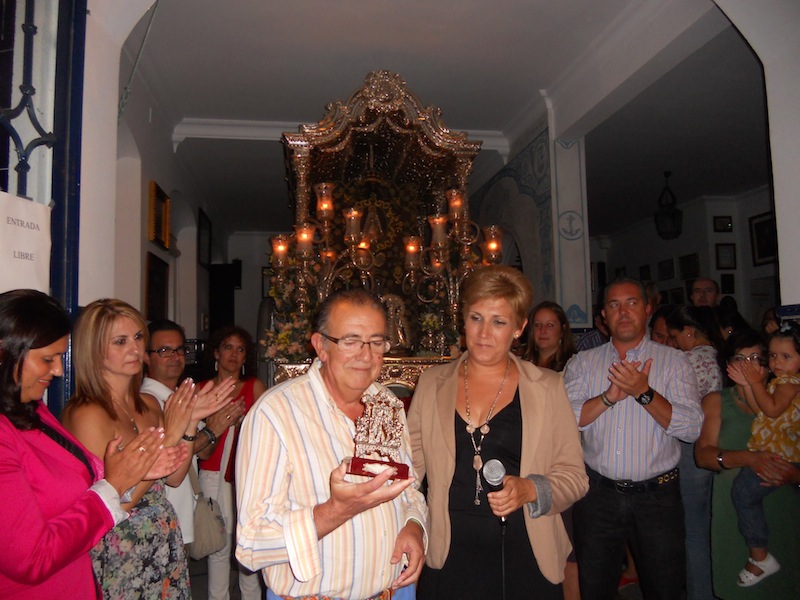 De manos de la Hermana Mayor, Diego recibe la réplica del frente de nuestra Carreta con el Simpecado