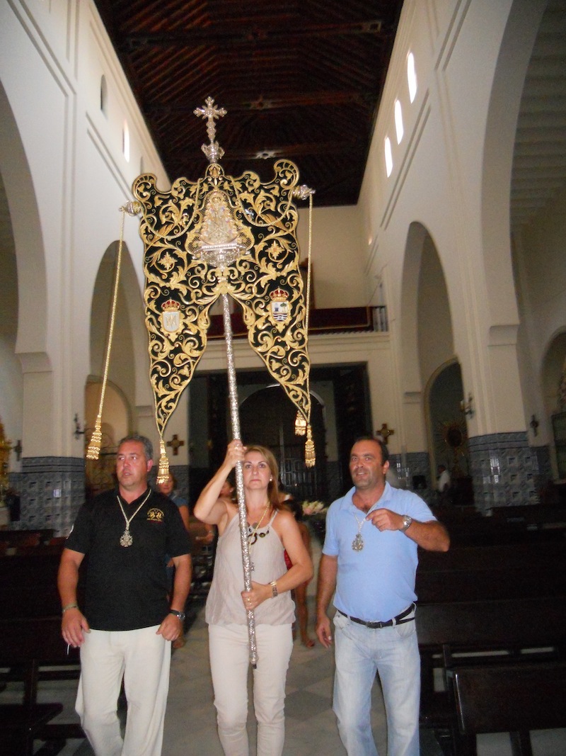 La Hermana Mayor porta el Simpecado en la Parroquia de Los Dolores hacia el Retablo