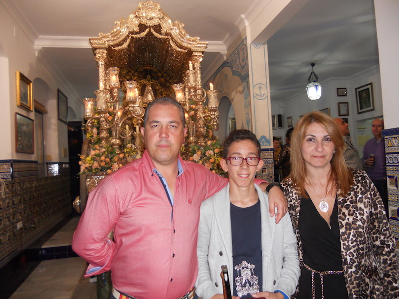 Ante la Carreta que porta el Simpecado, Antonio José Domínguez Contreras posa con la Hermana Mayor, Carmen Prieto y con el Presidente de la Hermandad, Pedro Jesús Álvarez