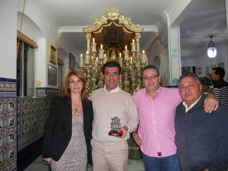 Ante la Carreta y con el Simpecado, la Hermana Mayor, Carmen Prieto, el Vicepresidente, Paco Moreno, y el Vicetesorero, Tomás Remedios, acompañan a Fernando Romero