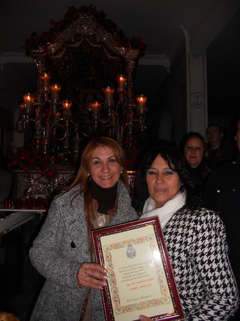 De manos de la Hermana Mayor, Carmen Prieto, Ani, en representación de Sabor Andaluz, recibe un regalo.