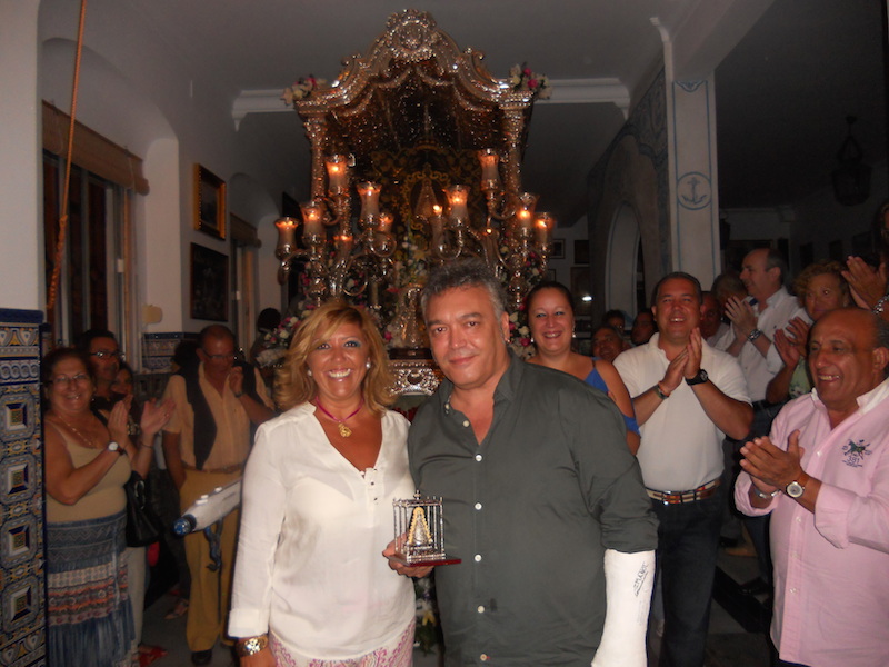 Mage Ojeda, en nombre del grupo, recibe de manos de la Hermana Mayor, Juana Rodríguez, una imagen de la Virgen