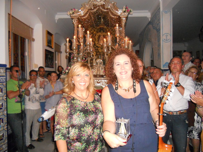 Mª Toni Contreras, en nombre de La Familia, recibe de manos de la Hermana Mayor, Juana Rodríguez, la imagen de la Virgen del Rocío en su Paso
