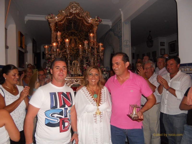 Diego, de Kalandraque, y Ramón, de Siempre Contigo, reciben de la Hermana Mayor, Juana Rodríguez, un recuerdo de la Hermandad