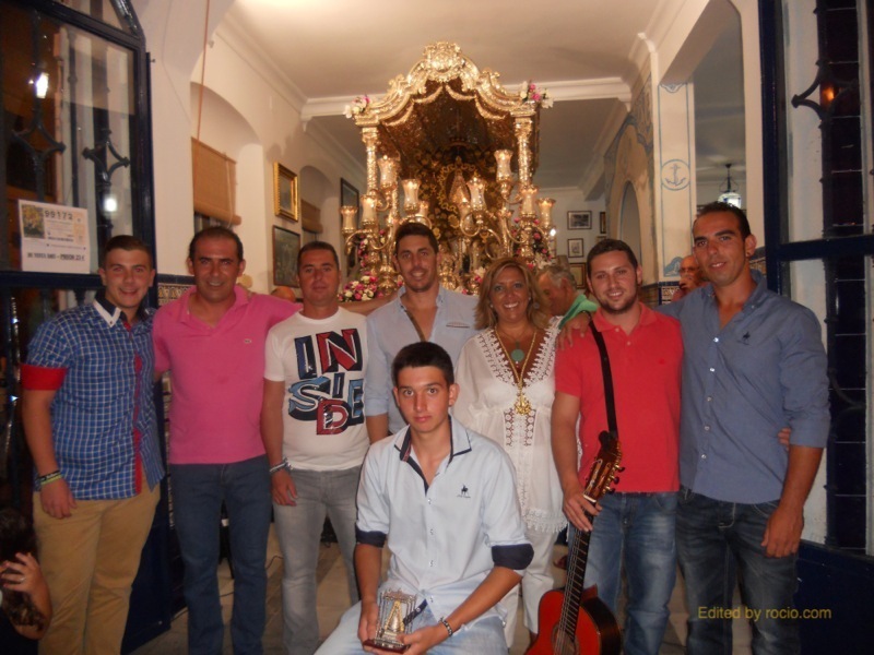 Ante la Carreta del Simpecado, la Hermana Mayor, Juana Rodríguez con -Los Amigos de Siempre Contigo y Kalandraque-